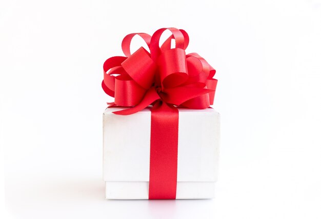 Caja de regalo blanco con arco de cinta roja sobre fondo blanco