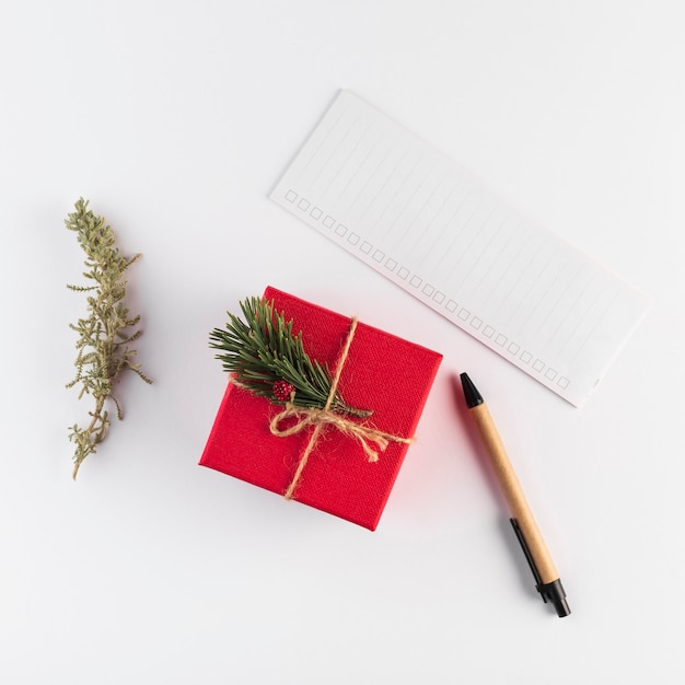 Caja de regalo cerca de papel y bolígrafo.