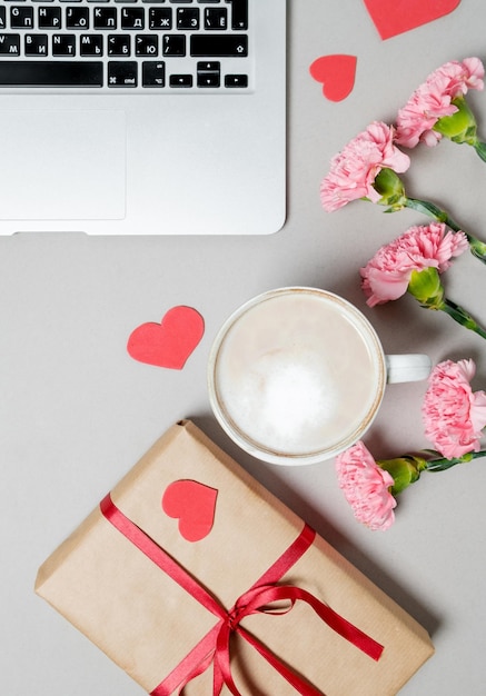 Caja de regalo para computadora portátil con corazón y café sobre fondo blanco Día de San Valentín concepto de compras en línea fondo de vacaciones Vista superior