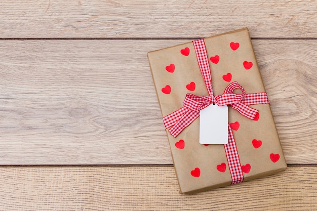 Caja de regalo con corazones en mesa de madera