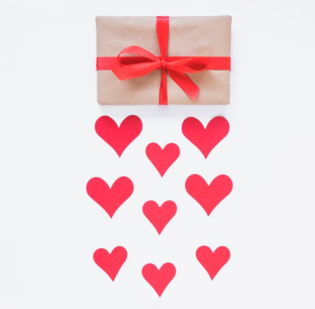 Caja de regalo con corazones rojos en mesa