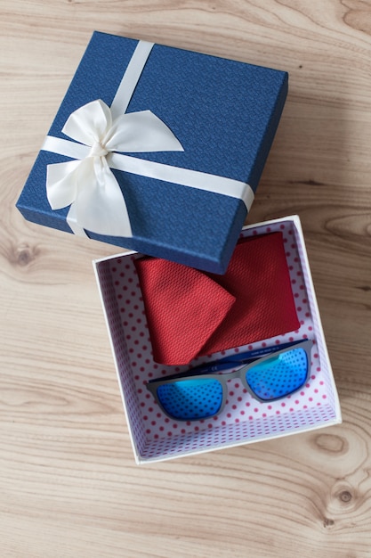 Foto gratuita caja de regalo con corbata y gafas de sol