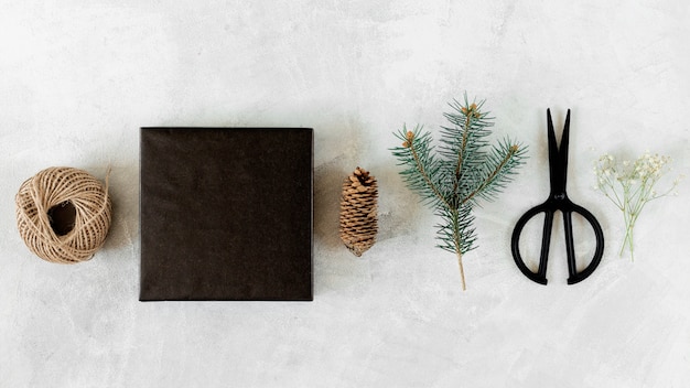 Caja de regalo con decoración navideña en mesa gris.