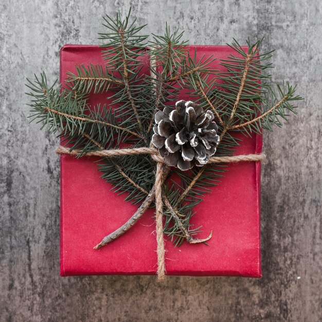 Caja de regalo decorada con gancho y ramitas de abeto.