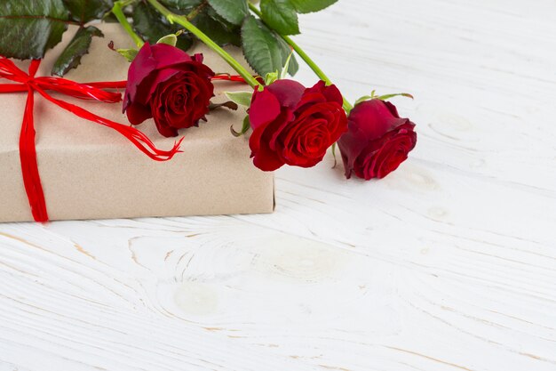 Caja de regalo en envoltura y flores frescas.