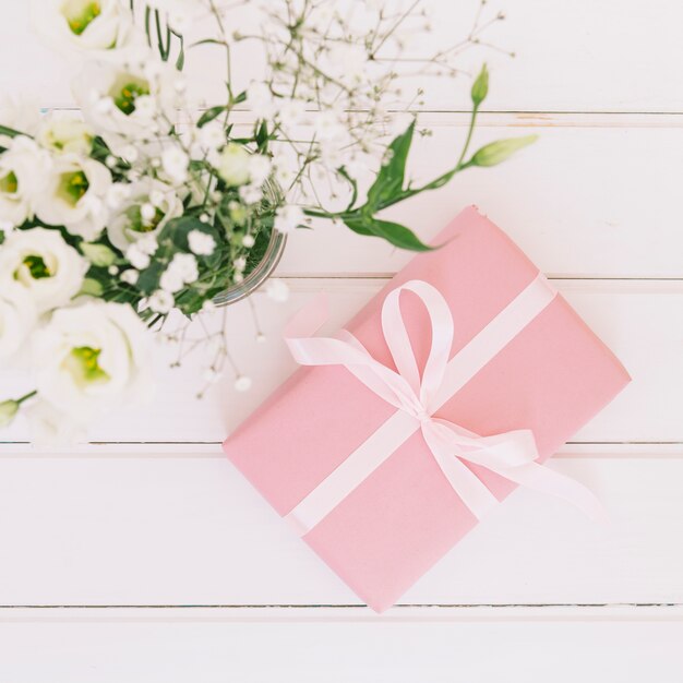 Caja de regalo con flores en florero.