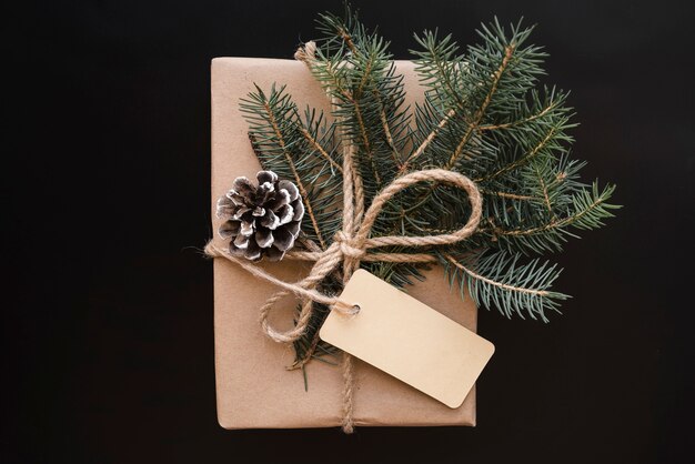 Caja de regalo con gancho, etiqueta y ramitas de abeto.