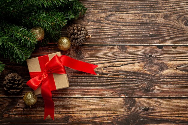 Caja de regalo con lazo de cinta roja sobre fondo de madera