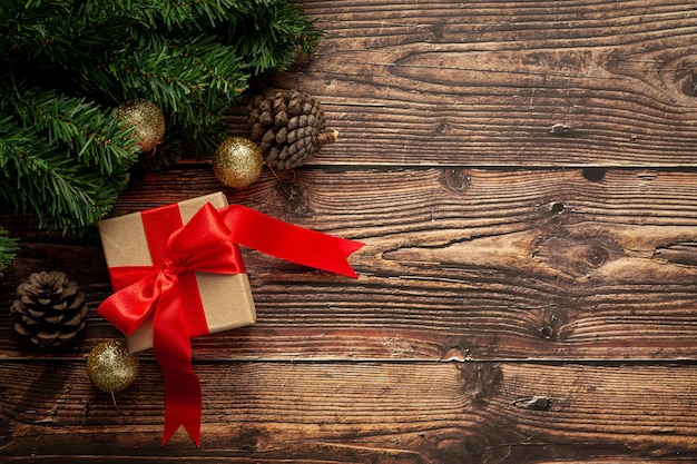 Caja de regalo con lazo de cinta roja sobre fondo de madera