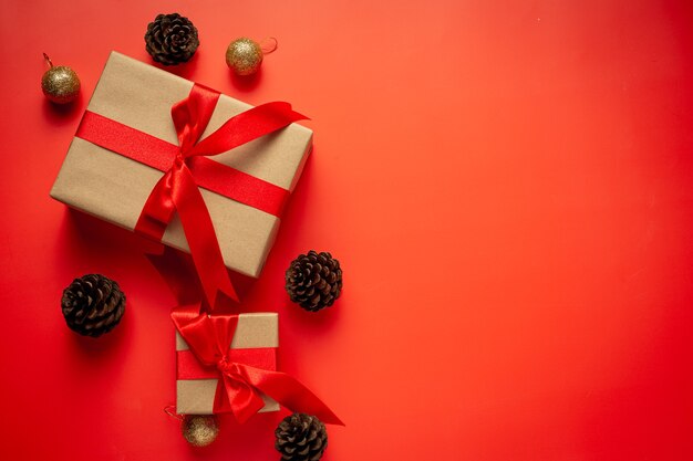 Caja de regalo con lazo de cinta roja sobre fondo rojo.
