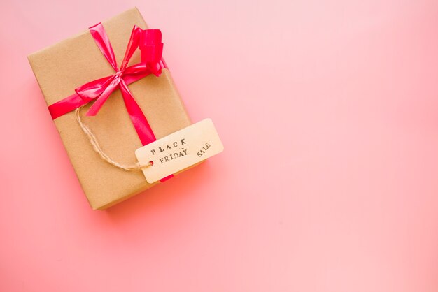 Caja de regalo con lazo rojo y etiqueta de venta.