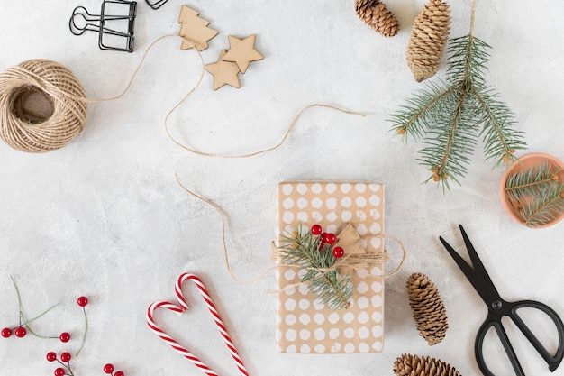 Caja de regalo de navidad con decoración en mesa gris.