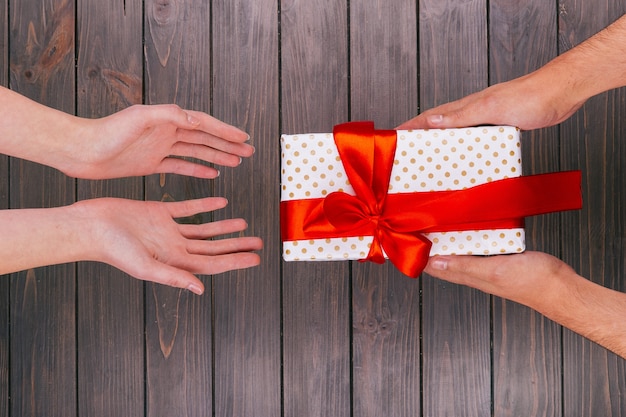 Foto gratuita caja de regalo de navidad entre las manos y las manos