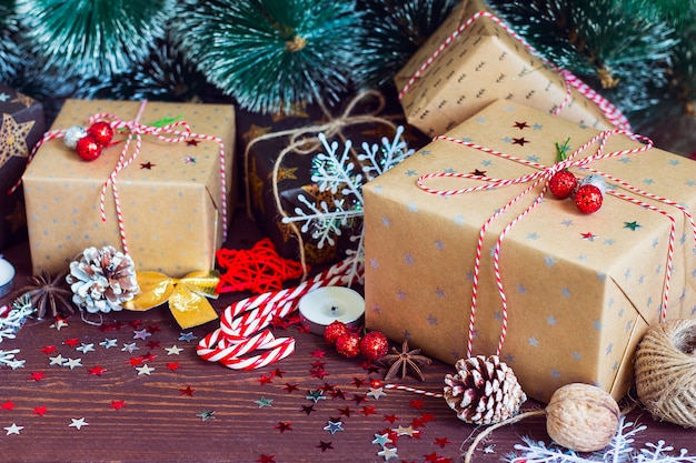 Caja de regalo de Navidad en mesa decorada con ramas de abeto de conos de pino