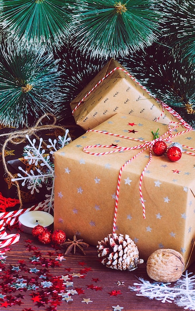 Caja de regalo navideña en una mesa festiva decorada con piñas de abeto ramas de abeto dulces caña