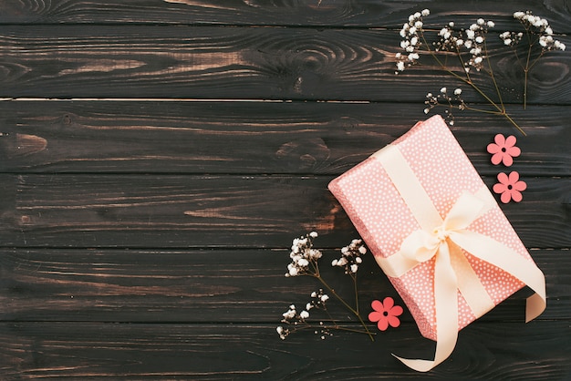 Caja de regalo con ramas de flores en mesa