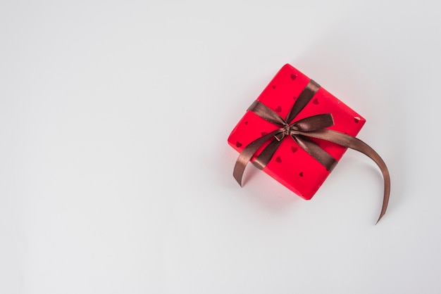 Caja de regalo roja con cinta marrón.