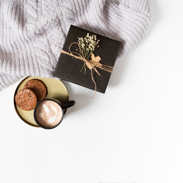 Foto gratuita caja de regalo con taza de café y galletas en la mesa