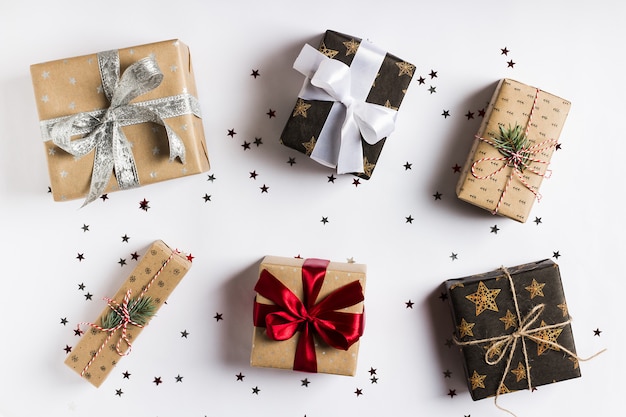 Caja de regalo de vacaciones de Navidad en mesa festiva decorada con estrellas de brillo