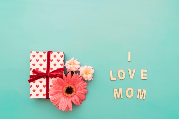 Caja de regalos, flores y lettering "i love mom"