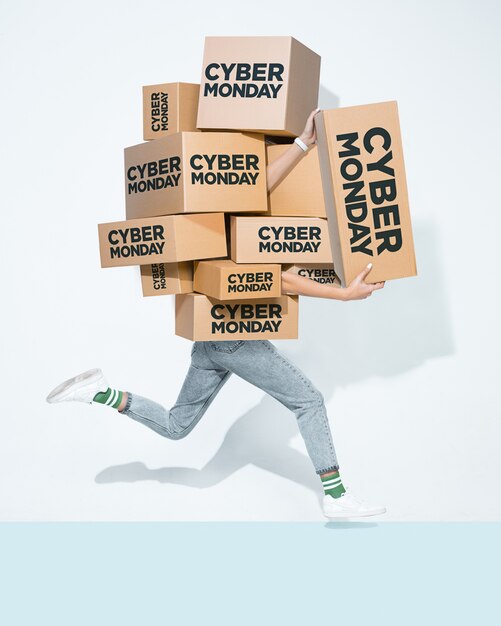 Cajas de cartón con inscripción de Cyber Monday en manos de un joven