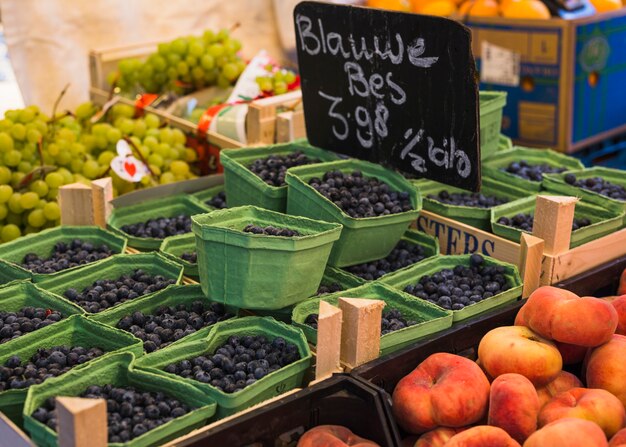 Cajas llenas de bayas jugosas saludables en el mercado.