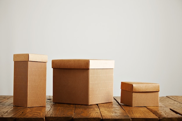 Cajas de papel beige de diferentes tamaños y formas en una mesa de madera en un estudio con paredes blancas