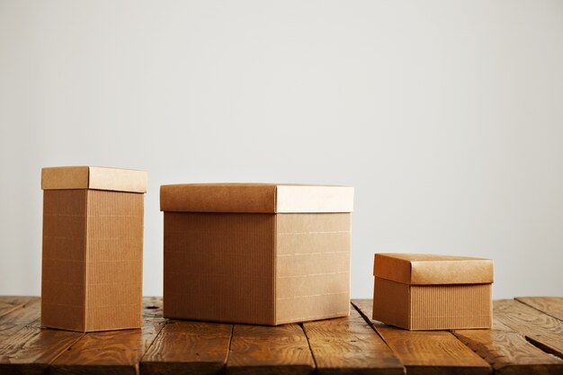 Cajas de papel beige de diferentes tamaños y formas en una mesa de madera en un estudio con paredes blancas