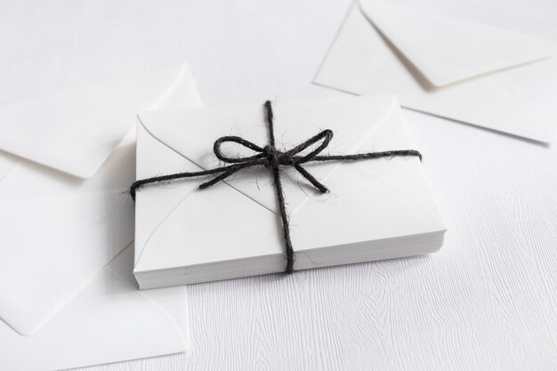 Cajas de regalo envueltas atadas con una cuerda negra y sobre sobre fondo blanco