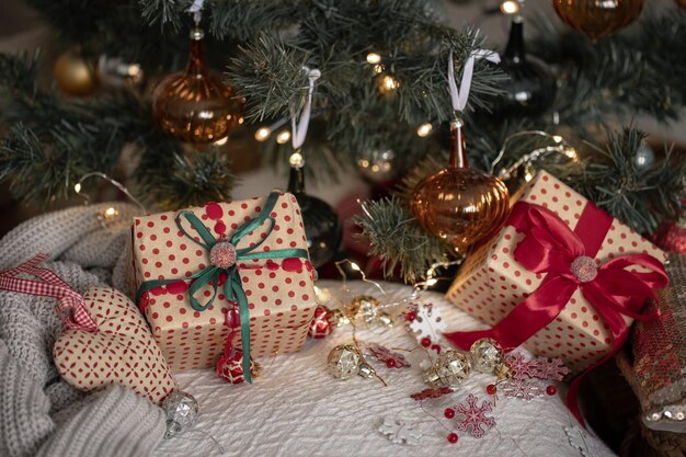 Cajas de regalo festivas bajo el primer plano del árbol de Navidad