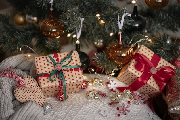 Cajas de regalo festivas bajo el primer plano del árbol de Navidad