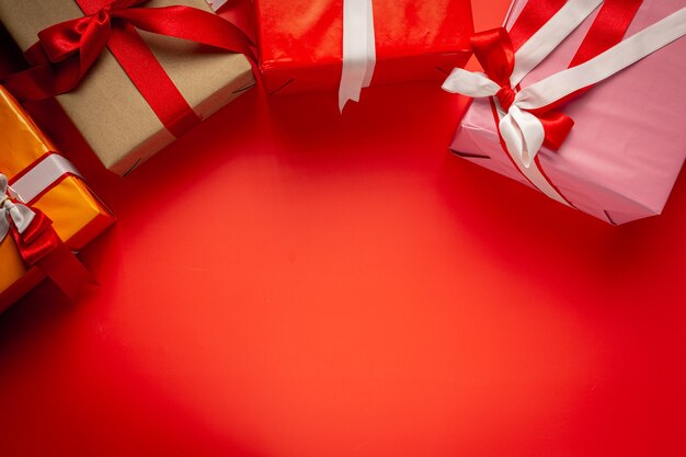 Cajas de regalo con lazo de cinta sobre fondo rojo.