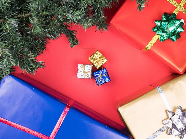 Cajas de regalo de Navidad y árbol de Navidad sobre fondo rojo. Adorno de tradición.