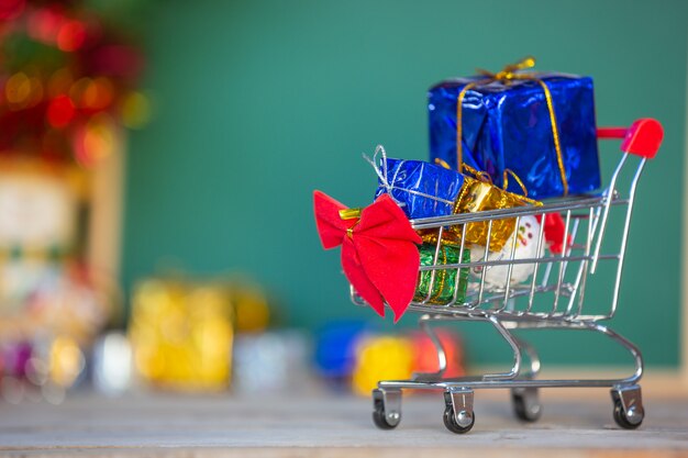 Cajas de regalo de navidad en varios colores colocadas en un carrito de compras