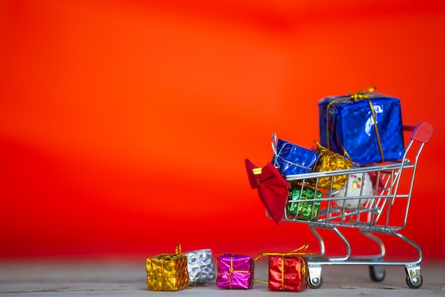 Cajas de regalo de navidad en varios colores colocadas en un carrito de compras