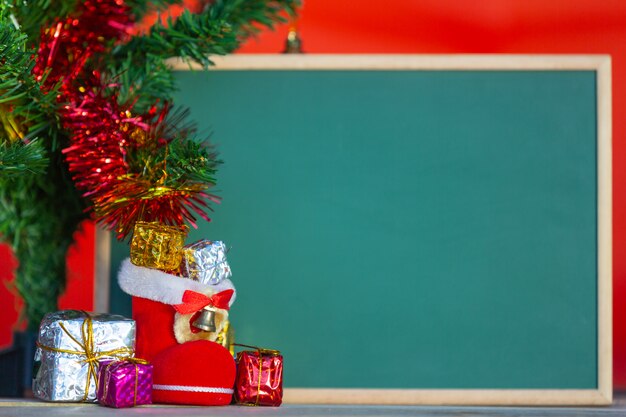 Cajas de regalo de Navidad en varios colores colocadas frente a la pizarra verde