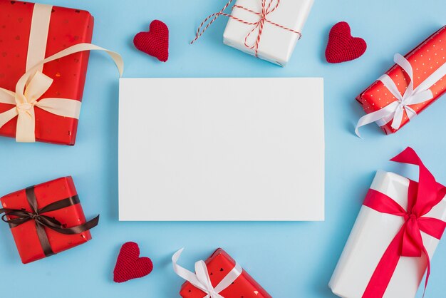 Cajas de regalo de San Valentín y corazones alrededor de papel.