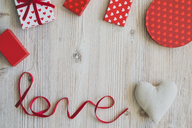 Cajas de regalo sobre una mesa de madera con la palabra "love" y un corazón