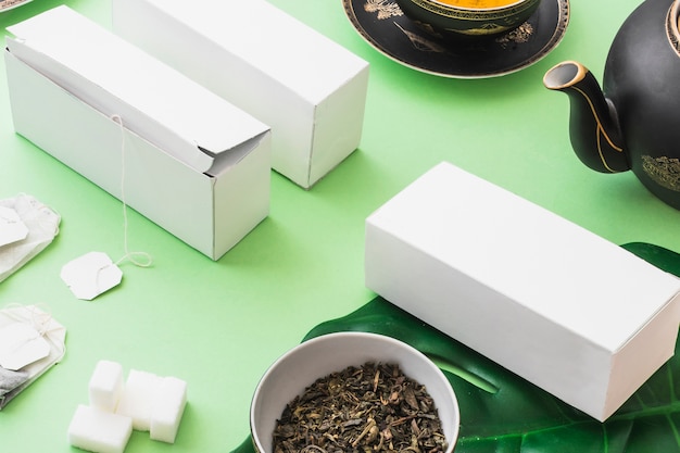 Cajas de té de hierbas con cubos de té y azúcar