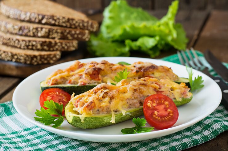 Foto gratuito calabacín relleno con pollo, tomate y cebolla con costra de queso