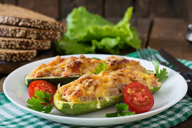 Foto gratuito calabacín relleno con pollo, tomate y cebolla con costra de queso
