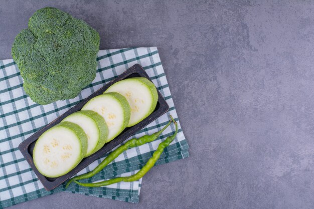 Calabacín verde y brócoli aislado sobre superficie azul