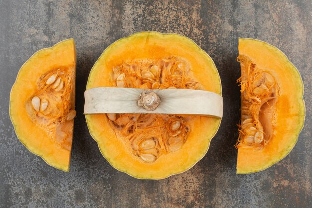 Calabaza amarilla en rodajas frescas en la pared de mármol