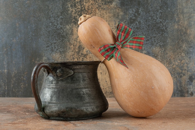 Foto gratuita calabaza con arco y hervidor antiguo sobre mármol.