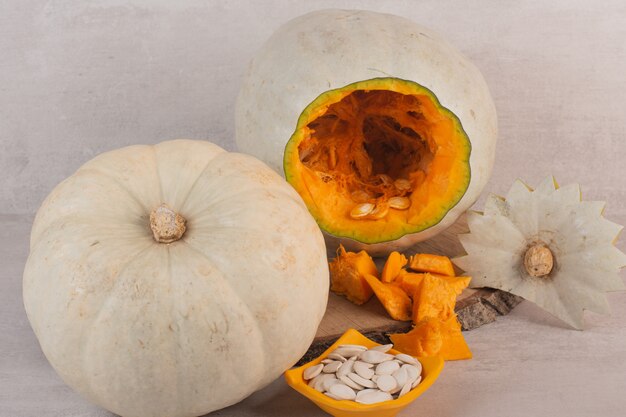 Calabaza blanca y semillas de calabaza sobre tabla de madera.