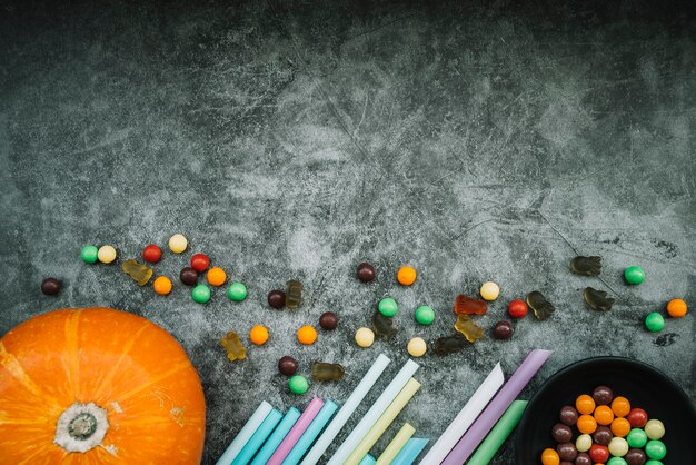 Calabaza cerca de pajitas y dulces