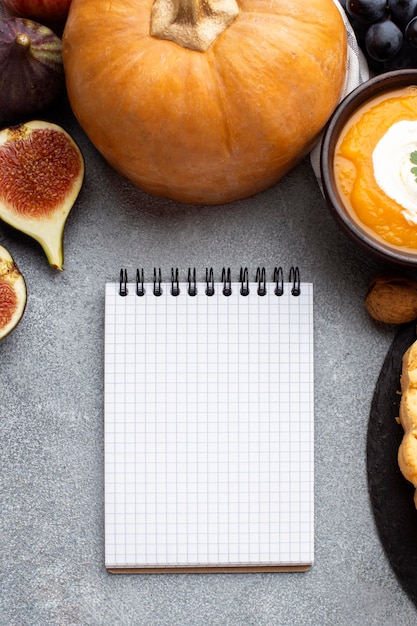 Foto gratuita calabaza cruda y cuaderno vacío