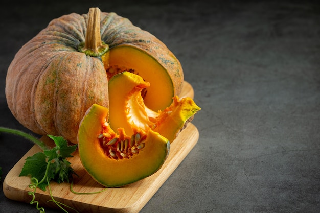 Calabaza cruda picada puesta sobre tabla para cortar madera