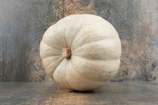 Calabaza gris solo fresca en la pared de mármol.