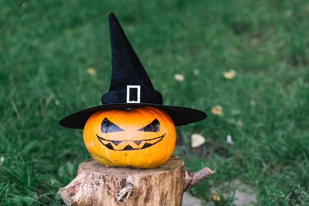 Calabaza de Halloween con sombrero en tocón